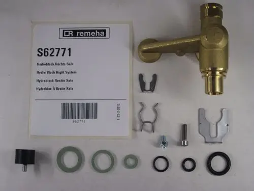 Remeha Hydroblock mit Zubehörteilen wie Dichtungen, Schrauben und Halterungen, angeordnet um eine zentrale Komponente aus Messing.